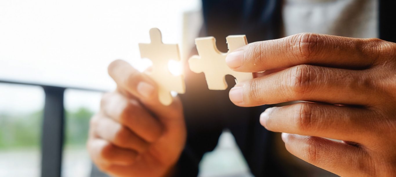 Business woman hands connecting jigsaw puzzle. Business solutions, success and strategy concept. Businessman hand connecting jigsaw puzzle.Close up photo with selective focus.